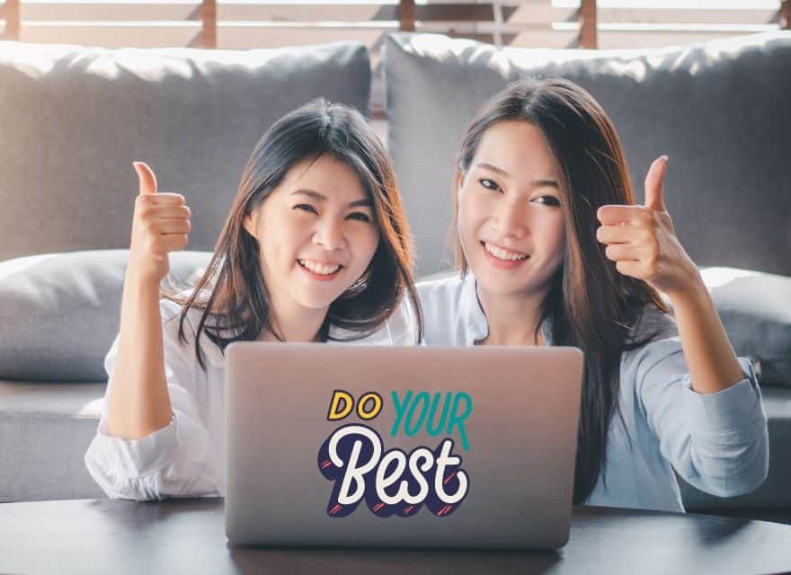 Zwei asiatische Frauen hinter einem Laptop heben ihre Daumen in die Höhe. Die besten Erfolgs Zitate