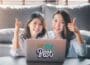Zwei asiatische Frauen hinter einem Laptop heben ihre Daumen in die Höhe. Die besten Erfolgs Zitate